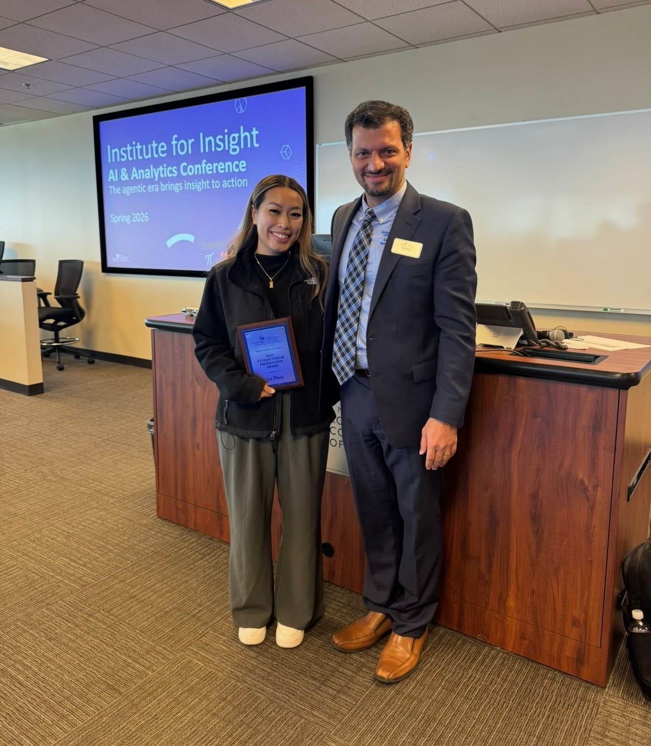 Savannah Vo holding the first place award plaque at the Institute for Insight AI and Analytics Conference